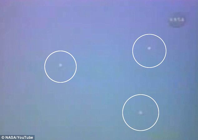 Did Nasa cover up mysterious ‘orbs’ that flew past shuttle mission? Newly uncovered video clearly shows unknown objects ‘buzzing’ Shuttle Atlantis