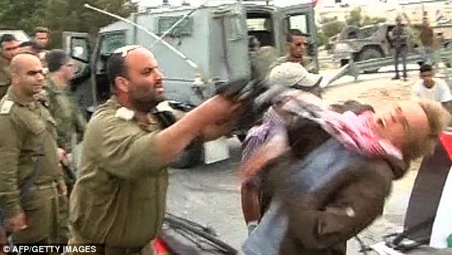 The True Face of Brutality in the Middle East: Israeli officer hits unarmed protester in the face with rifle
