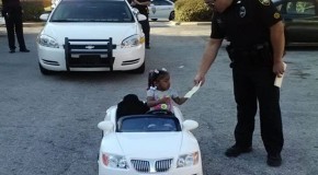 Aren’t you a little young to be behind the wheel? Adorable moment that toddler is ‘pulled over’ by police in her toy convertible and given a $4 ticket for reckless driving