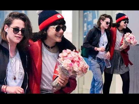 Kristen Stewart is greeted with flowers at the airport by rumoured new girlfriend SoKo